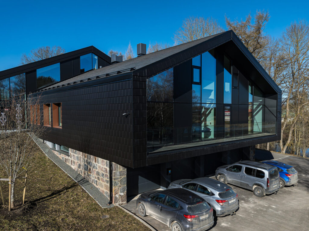 Viljandi Vallamaja modernne hoone klaasfassaadi ja paekivist sokliga kevadpäeval.